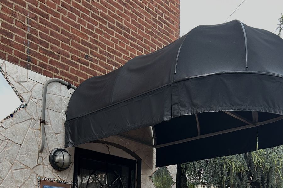 A black fabric door awning after cleaning
